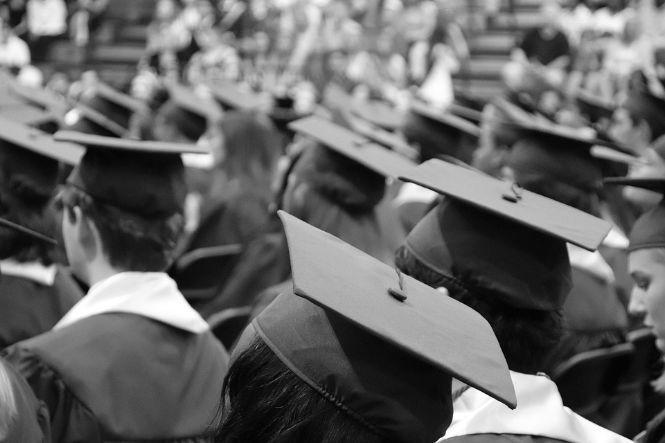 students sit at graduation