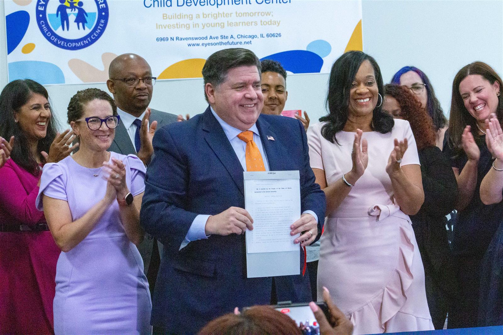 Gov. JB Pritzker holds up Senate Bill 1 after signing it into law