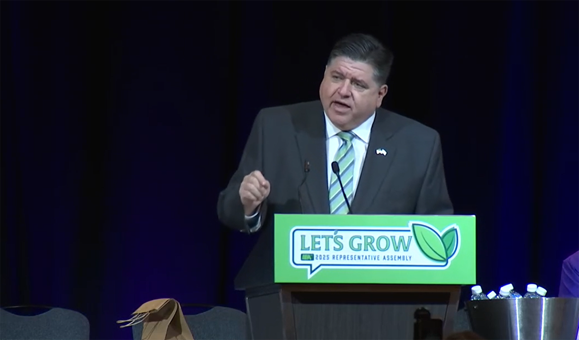 JB Pritzker addresses crowd in front of a podium