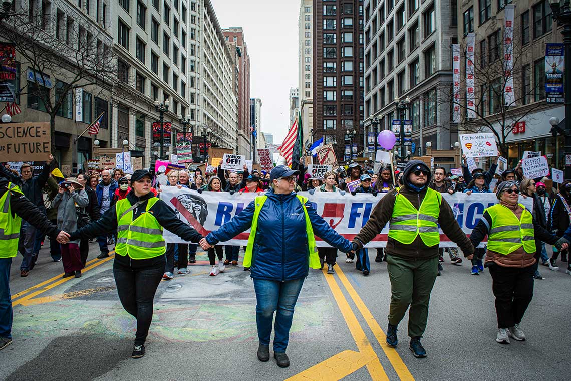 Protest participants walk down street hand in hand