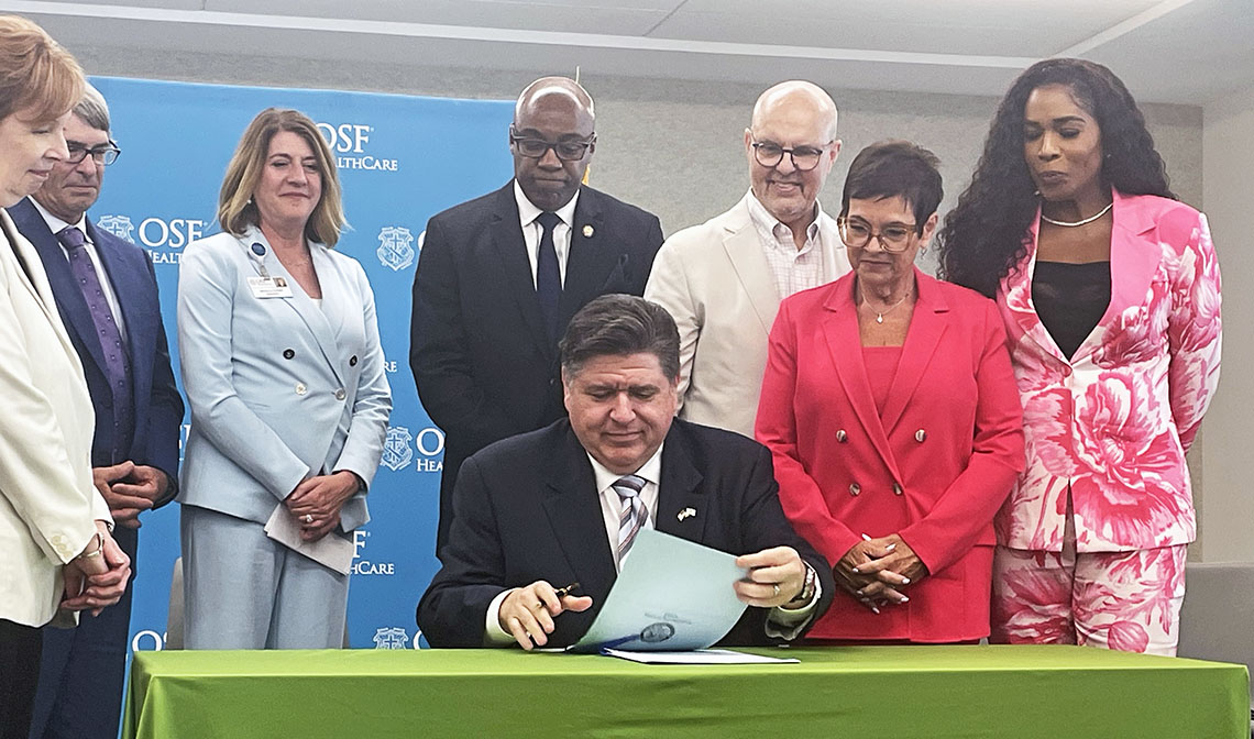 JB Pritzker signs paperwork