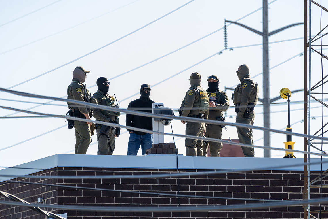 Border Patrol agents on a roof.