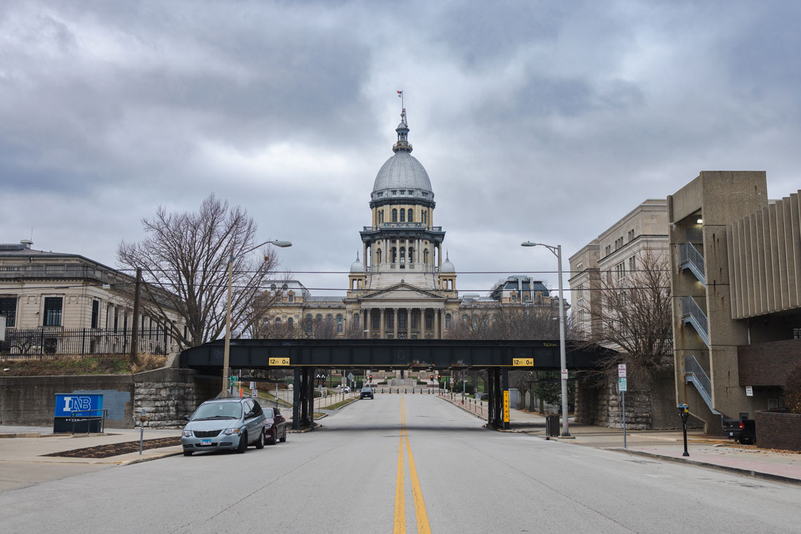 State capitol building in front of a railroad bridge