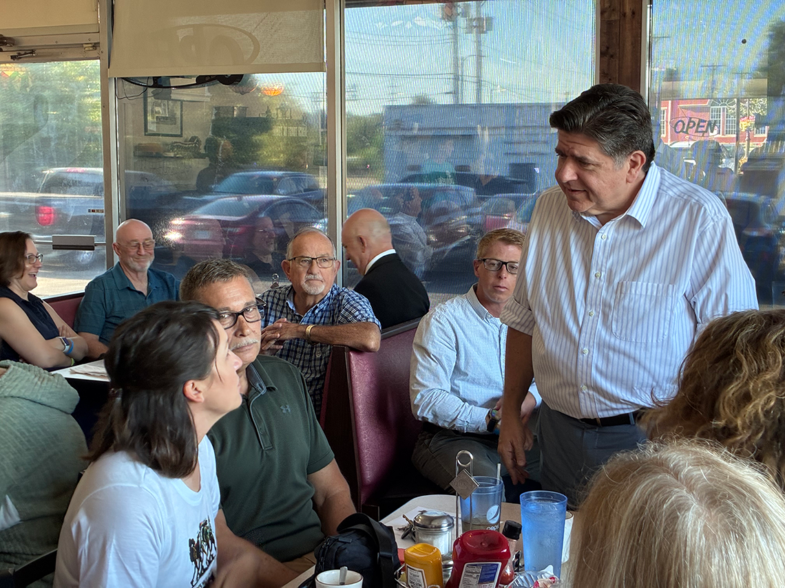 JB Pritzker speaks with diner customers.